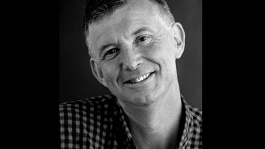 Headshot of person smiling against a plain background