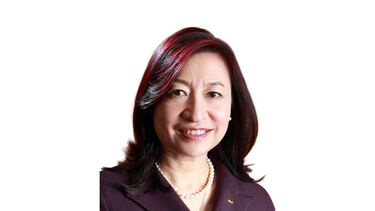 Headshot of a person with medium length straight hair smiling towards the camera