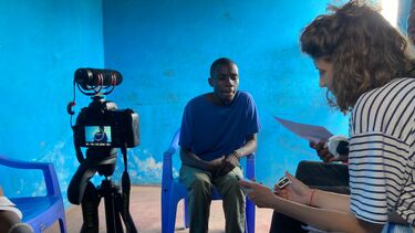 A man in Nairobi sitting in front of a camera being filmed for an interview