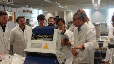 Researchers wearing lab coats doing practical work
