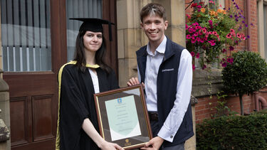 Elizabeth Frewer in graduation gown with certificate