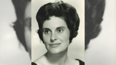 A glamorous professional black-and-white headshot of a younger Maureen in a black off-the-shoulder dress, with dark hair cropped fairly short