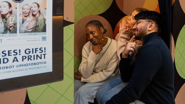 Three people posing in a photobooth