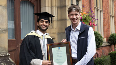Vinay Meisuria in graduation gown with certificate 