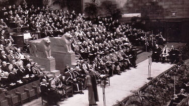 A wide-angle black-and-white shot of an honorary degree ceremony in 1948, in a large ornamental room