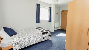 The bed and wardrobe in an accessible en-suite bedroom at Ranmoor & Endcliffe