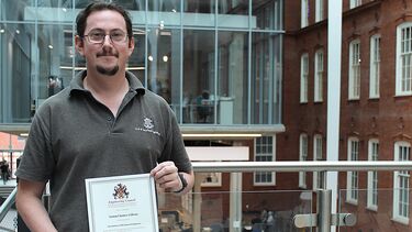 Portrait of engineering technician holding a certificate