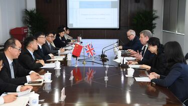 A group of staff from the universities of Sheffield and Tongji sit around a table and talk.
