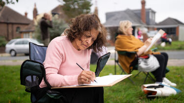 Older adult drawing in park