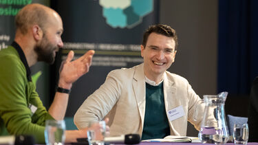 Dr Joshua Forstenzer and Professor Thomas Webb speaking on stage at the Sustainability Symposium 2025