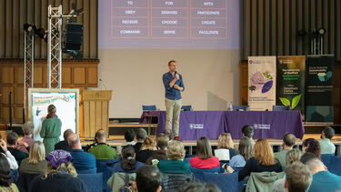 Jon Alexander speaking onstage at the Sustainability Symposium 2025
