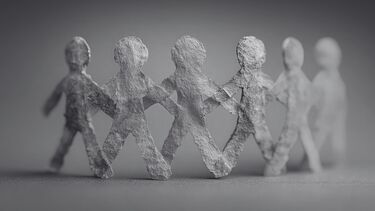 Paper cut-outs of people stand arm in arm