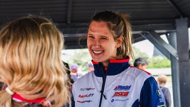 Women smiling at race track in sports gear 