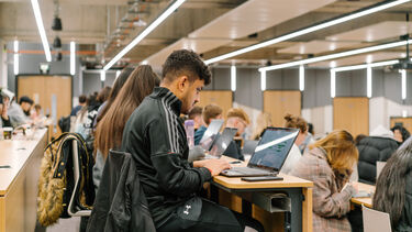 Student with laptop in lecture theatre