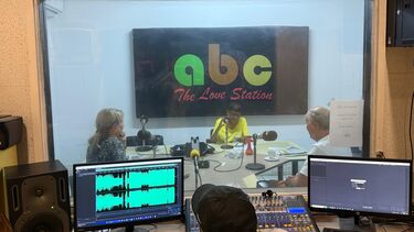 three people in a radio studio called ABC the love station