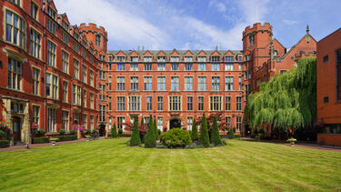 image shows the quadrangle of Firth Court. Firth Court is a traditional red brick university building and quad features a lawn, trees and central water feature.