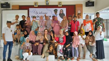 A group of attendees, including Grantham Scholar, Eva Adriani, and her supervisor, Olga Cam, posing on the stage at a conference