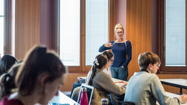 A lecturer stood at the front of the room leading a seminar
