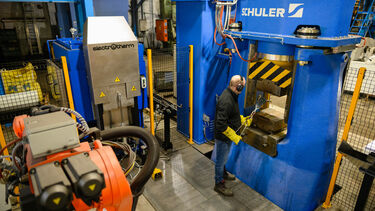 Operator loads a hammer forge