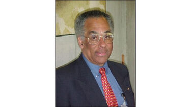 Hugo Alleyne looking at the camera with a soft smile.