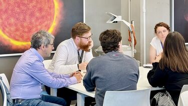 Image of people on a table at a conference