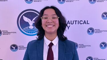 Aerospace engineering alumna holding an award and smiling