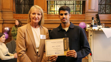 Kris is receiving Placement Year Award from a lady