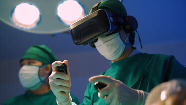 A surgeon wearing a VR headset and holding VR controllers.