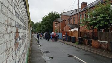 image of people standing in street with umbrellas