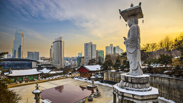 Korean statue overlooking city landscape