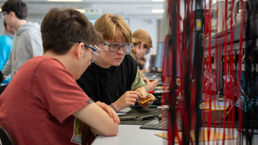 Two boy students are working in pairs and testing a circuit in the E&C lab