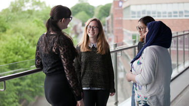 Group of students enjoying a discussion on the balcony of the Student Union