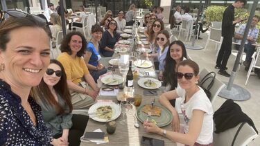 A group selfie along a set dinner table