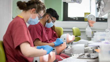 Two students practicing their clinical skills in the Clinical Skills Learning Environment