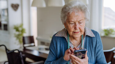 Adobe stock image of an older person using a mobile phone