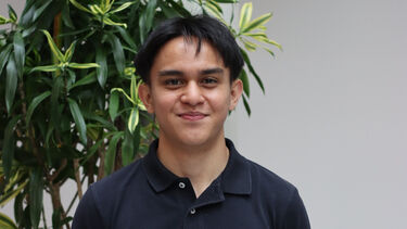  Student Asyraf Johari standing by a plant.
