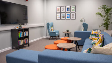 A TV, a blue sofa and coffee tables
