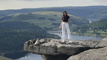 Alicia stands on a rock in the Peak District
