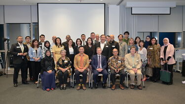 Alumni in Indonesia gathered together and smiling at the camera.