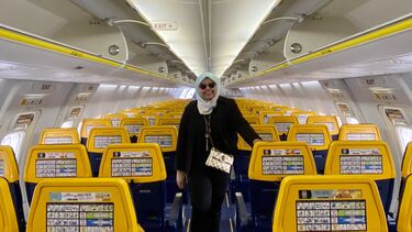 Grantham Scholar Su Natasha Mohamad standing in the aisle of an airplane
