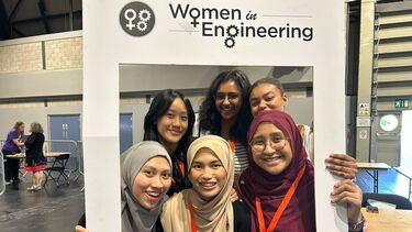 A group of six diverse women, standing inside a large frame with the text 'Women in Engineering'