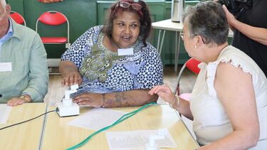 Two people using music device