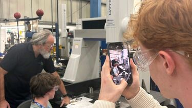 A man takes a photo of a teacher and student 