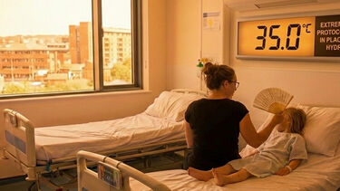 A parent fans a child on a hospital bed