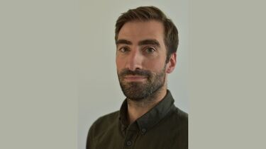 Headshot of Barney Guiton on a grey background