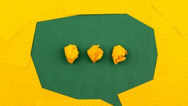 A speech bubble made from yellow and green sheets of paper