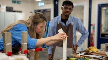 Two students working on model in workshop