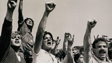 A group of miners yelling with their fists in the air