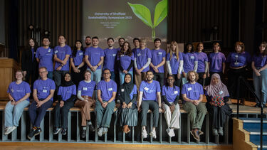 A group photo of the Grantham Scholars standing on the stage at the Sustainability Symposium 2025