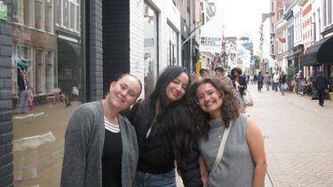 three young women posing for the camera in a shopping street in Groningen